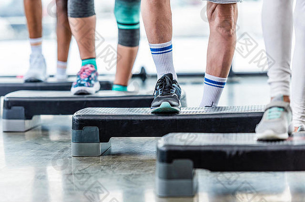 部分视图爱运动的人锻炼一步平台健身房