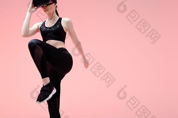 运动型女人虚拟现实耳机锻炼孤立的粉红色的