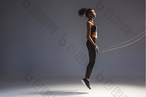 运动非洲美国女运动员锻炼跳过绳子灰色复制空间