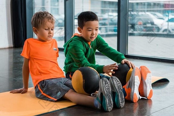 多元文化的孩子们球腿坐着健身席健身房