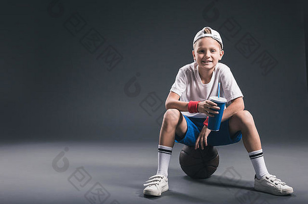13岁以下的男孩苏打水喝坐着<strong>篮球</strong>球灰色背景