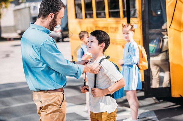 英俊的父亲会说话的儿子学校前面学校公共汽车同学们