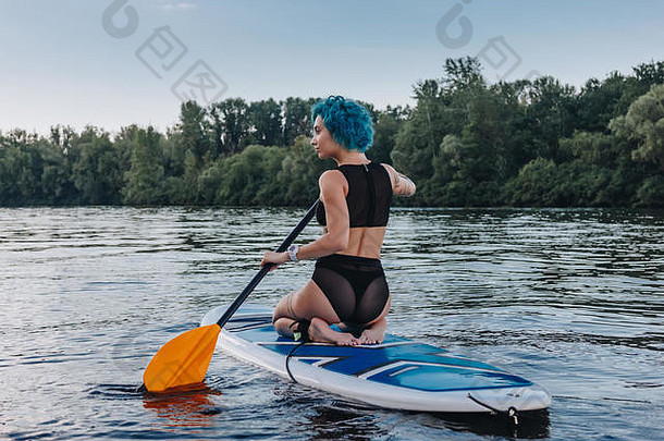 回来视图女人蓝色的头发坐着桨董事会河