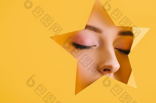 肖像美丽的女人闪亮的化妆纸明星形状的洞关闭眼睛孤立的黄色的