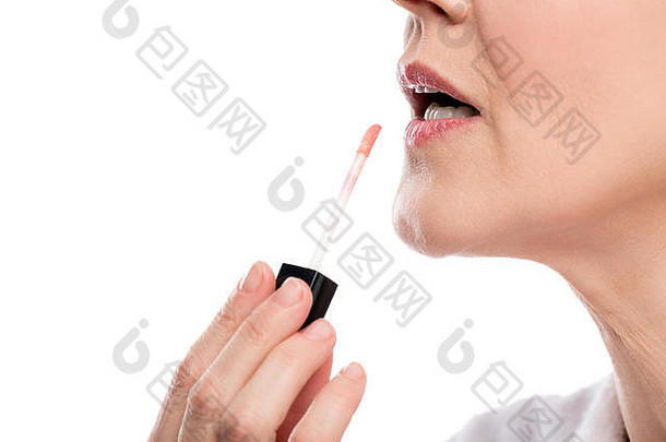 部分拍摄成熟的女人应用唇光泽孤立的白色