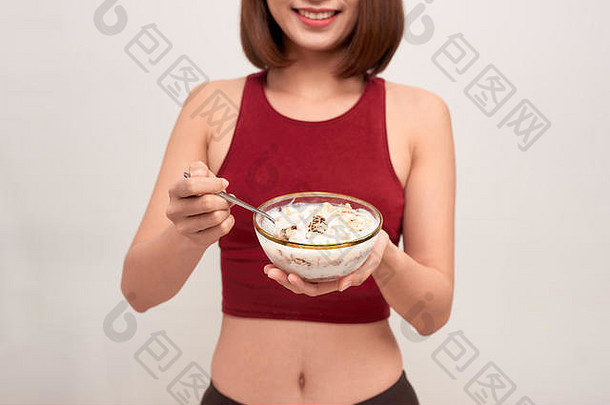年轻的女人休息吃健康的燕麦片锻炼