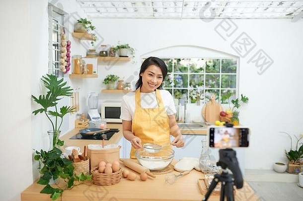 漂亮的年轻的亚洲女食物博主工作视频解释烹饪菜