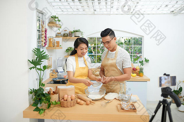 年轻的亚洲夫妇烹饪记录生活视频视频博客社会媒体专业相机
