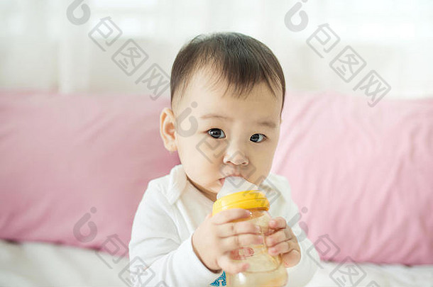 甜蜜的婴儿女孩吸牛奶瓶首页