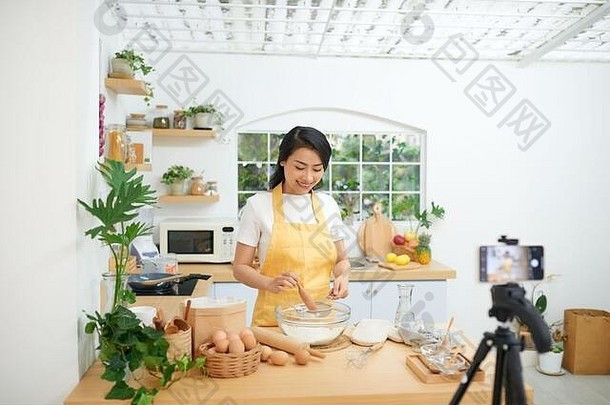 漂亮的年轻的亚洲女食物博主工作视频解释烹饪菜