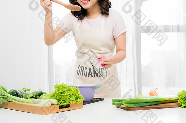 肖像美丽的年轻的女人烹饪汤蔬菜首页