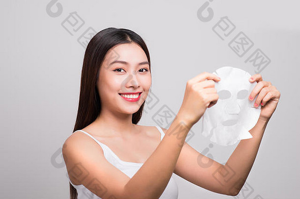 美丽的亚洲女人应用纸表面具脸白色背景