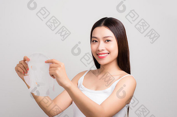 美丽的亚洲女人应用纸表面具脸白色背景