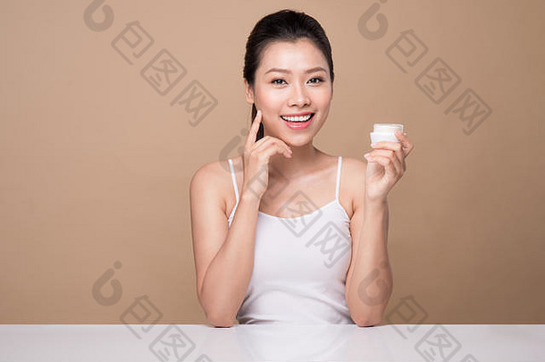 护肤品美丽的亚洲女人显示保湿霜乳液产品