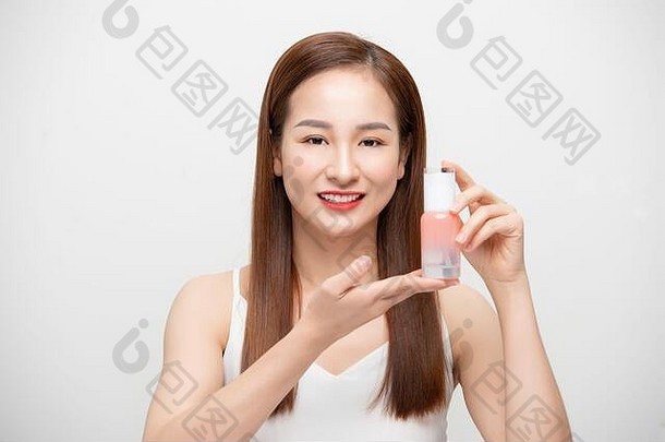 美丽的年轻的亚洲女人短头发持有化妆品产品健康的清洁新鲜的皮肤