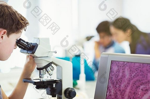 男孩学生显微镜进行科学实验实验室教室