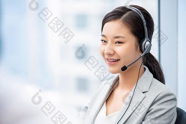 微笑美丽的亚洲女客户服务操作符工作调用中心办公室