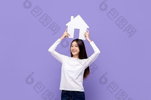 微笑美丽的亚洲女人持有房子象征开销孤立的紫色的背景