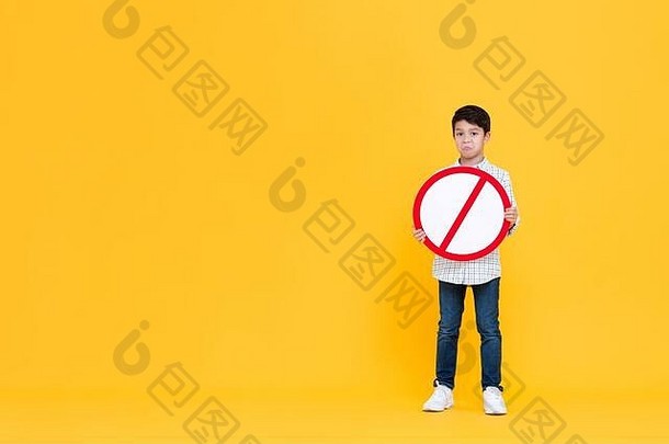 穿着站撅嘴年轻的亚洲男孩持有红色的禁止标志黄色的孤立的工作室背景复制空间