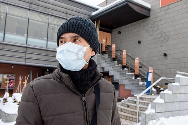 亚洲旅游男人。穿面具保护冠状病毒冬天日本