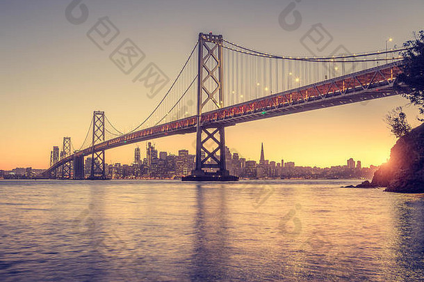 经典全景视图三旧金山天际线著名的奥克兰湾桥照亮美丽的金晚上光日落夏天三