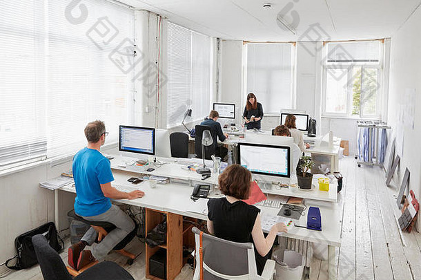 现代办公室工作站工作人员升高视图人坐着桌子男人。人体工程学跪垫椅子