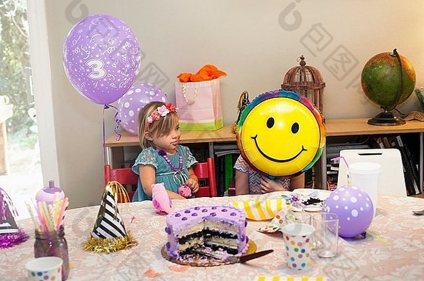 女孩坐着生日聚会，派对表格蛋糕玩笑脸脸气球