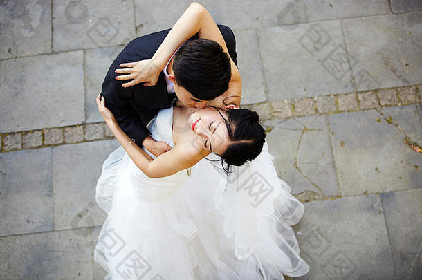 年轻的亚洲新娘新郎拥抱接吻跳舞高角视图