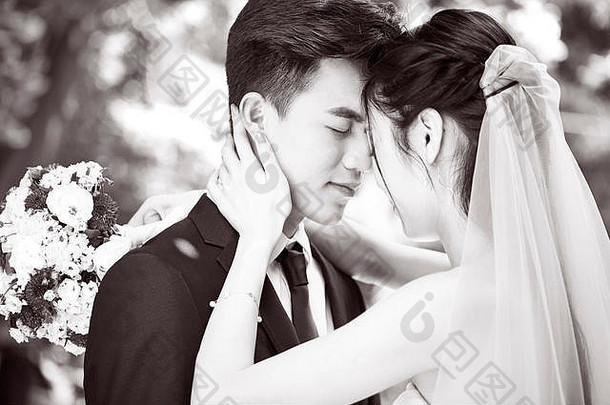年轻的亚洲新娘新郎接吻婚礼仪式黑色的白色