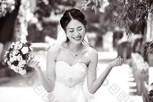 年轻的美丽的亚洲新娘欢乐花束手黑色的白色
