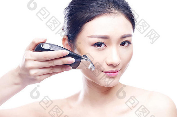 年轻的亚洲女人脸水疗中心仪器孤立的白色