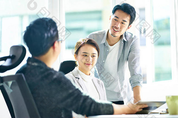 年轻的亚洲企业高管会议办公室讨论业务数字平板电脑