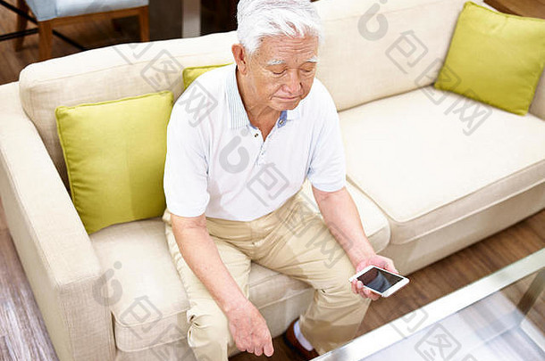 高角视图孤独的亚洲高级坐着沙发上手机手