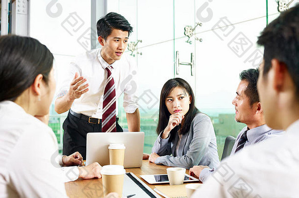 年轻的亚洲商人说话同事会议现代办公室