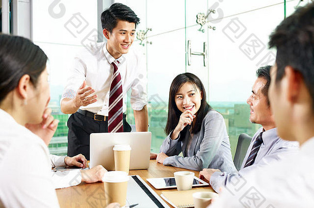 年轻的亚洲商人说话同事会议现代办公室