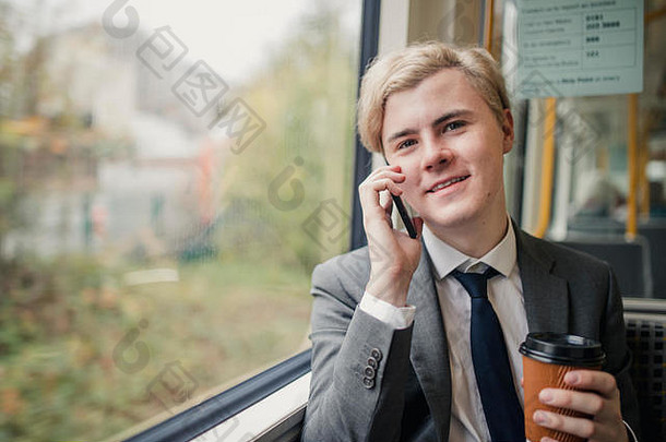 年轻的商人使电话调用火车上下班工作