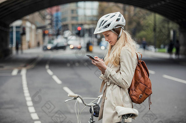 年轻的女商人检查通知移动电话骑自行车工作