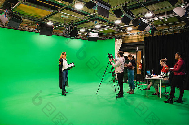 广角拍摄多民族集团人工作电影工作室成熟的高加索人女人展示前面绿色scre