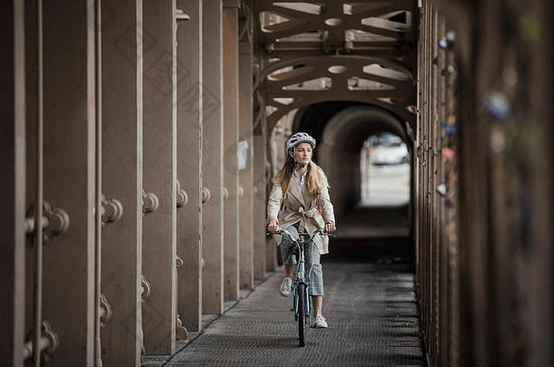 年轻的女成人骑自行车桥