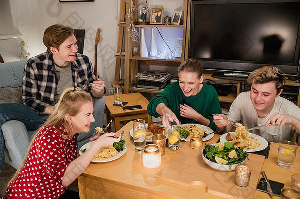 年轻的夫妻享受晚餐聚会，派对首页吃自制的意大利面第一大大蒜面包沙拉