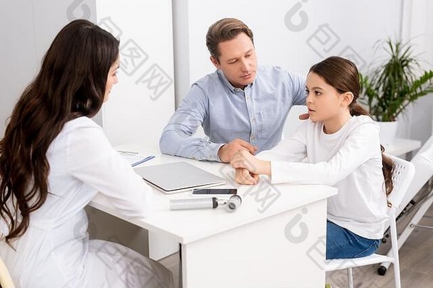 细心的父亲坐着担心女儿咨询ent医生
