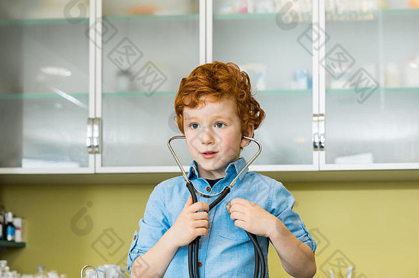 可爱的红色的头发的男孩听诊器诊所