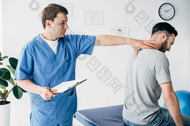 脊椎指压治疗者诊断笔按摩脖子男人。医院