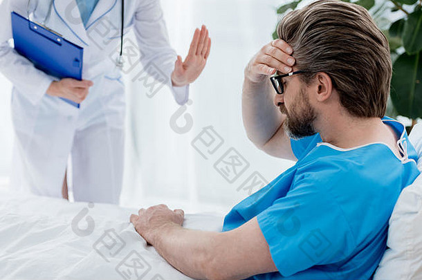 裁剪视图医生白色外套平静的伤心病人医院