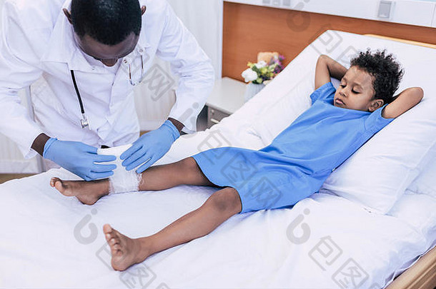 非洲美国医生医疗手套把绷带病人受伤的腿