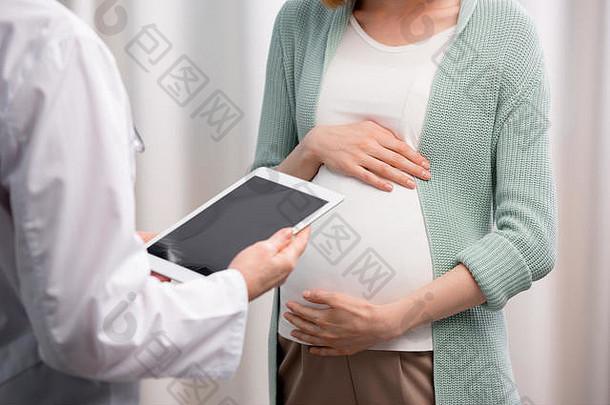 部分视图医生怀孕了女人讨论怀孕过程诊所