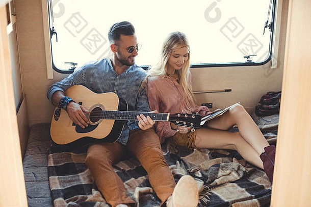 快乐的男朋友玩吉他女朋友持有乙烯基记录内部郎普