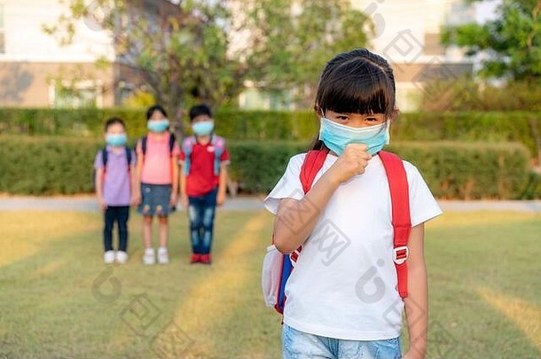 亚洲女孩学前教育孩子学生穿健康的脸面具打喷嚏朋友背景建议英尺距离