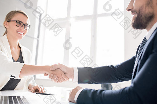快乐的业务合作伙伴使握手办公室