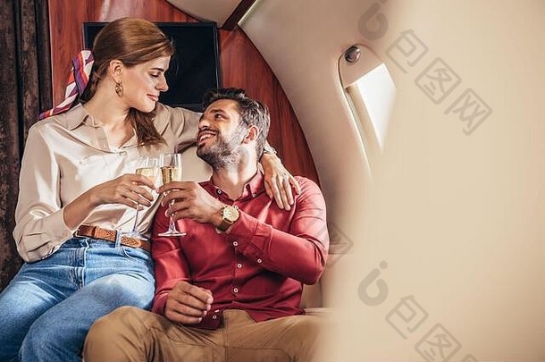 微笑的男朋友女朋友无比的香槟眼镜私人飞机